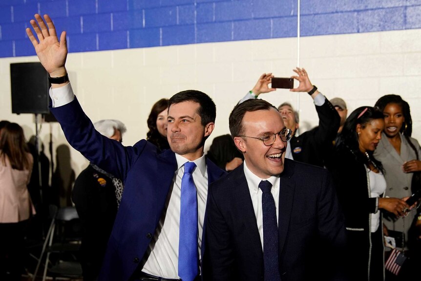 Pete Buttigieg and his husband Chasten wave to the crowd