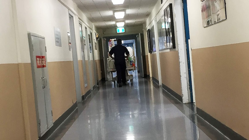 Patient being wheeled down a corridor at Royal Hobart Hospital.