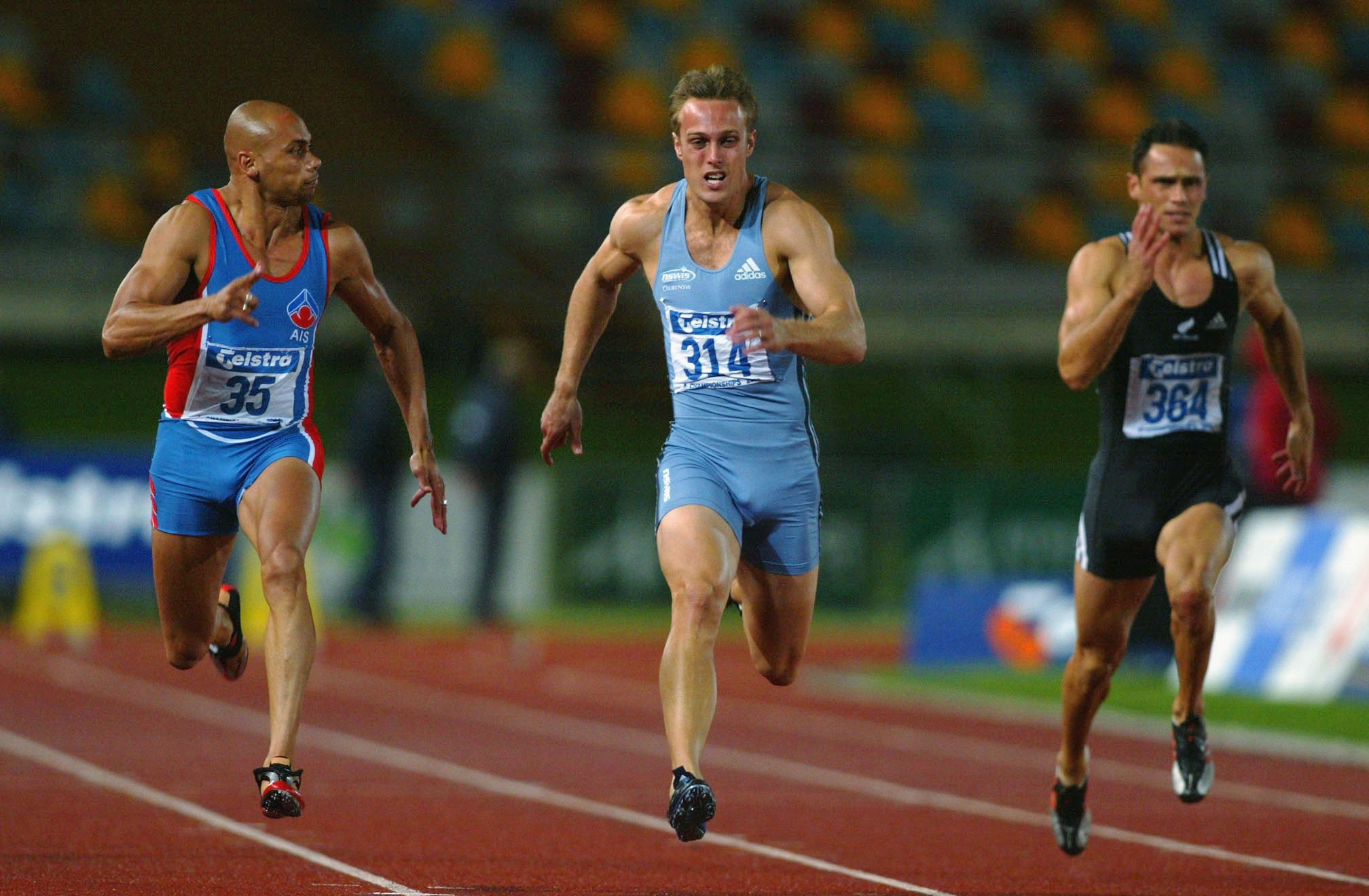 Patrick Johnson looks at Matt Shirvington during a 100m race. Patrick looks at Matt and Matt grits teeth mid stride.