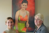 A teenage girl and her mother stand in front of a painted portrait of a young woman in a formal dress