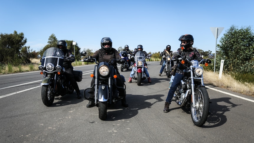 A group of female motorcycle riders on the road.