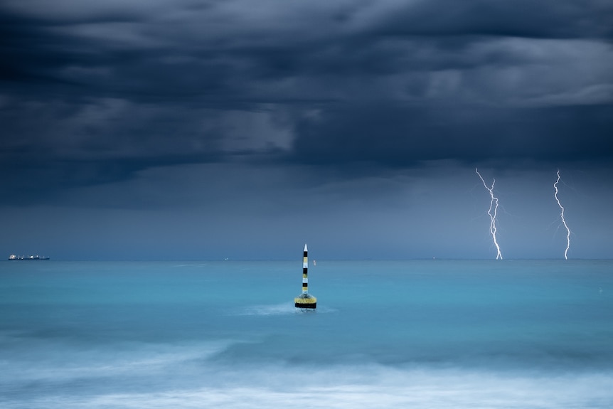 Lightning seen in the distance off Cottesloe Beach amid storm clouds.