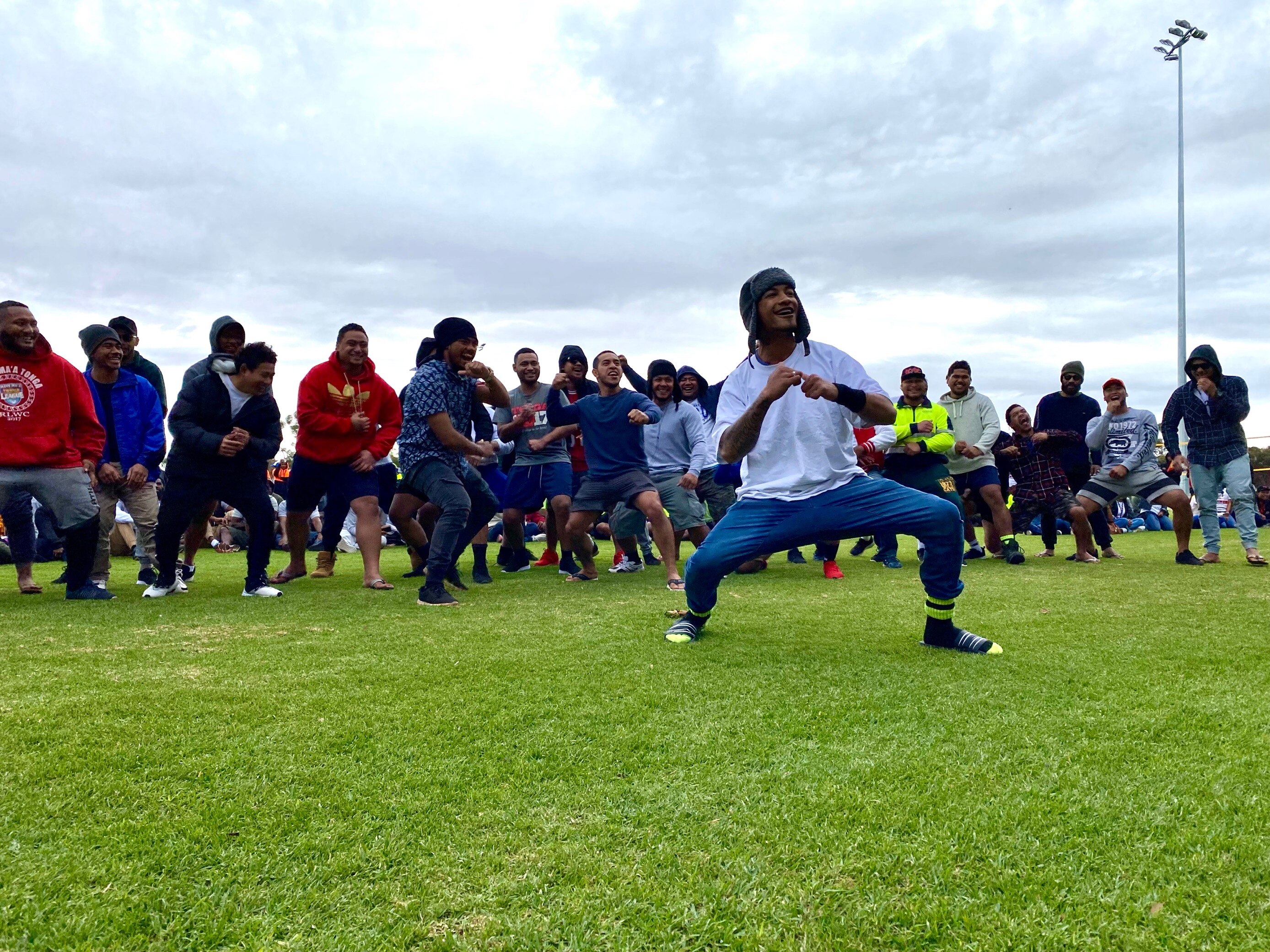 Men dancing at a sports carnival. This mob, however, are not in traditional dress.