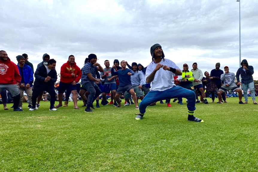 Men dancing at a sports carnival. This mob, however, are not in traditional dress.