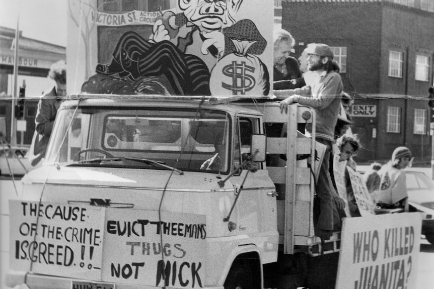 People riding on the back of a truck with a variety of signs including one that says 'Keep Sydney Green'.