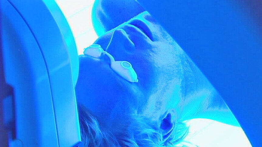 Man using a tanning bed in a solarium