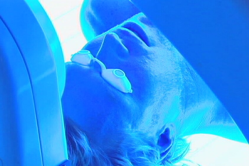 Man using a tanning bed in a solarium