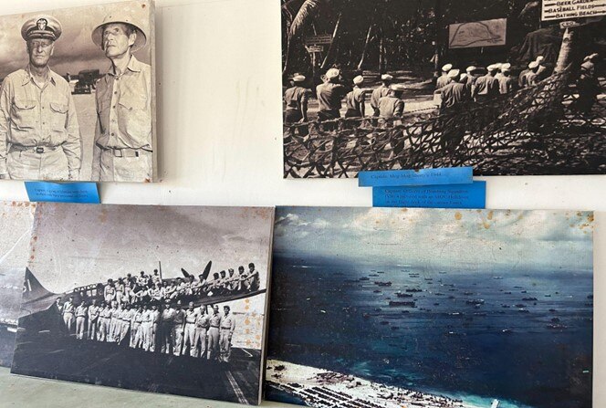 Four images of world war II in the Pacific hang on wall. 