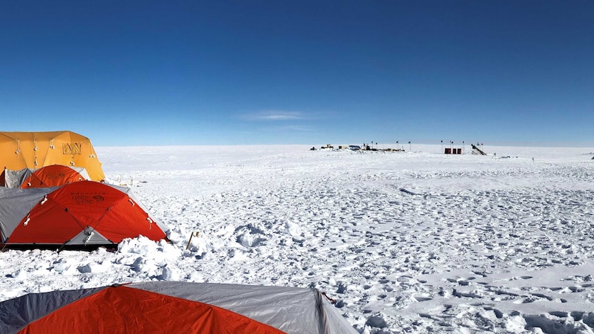 A camp in Antarctica with tents on a cloudless day