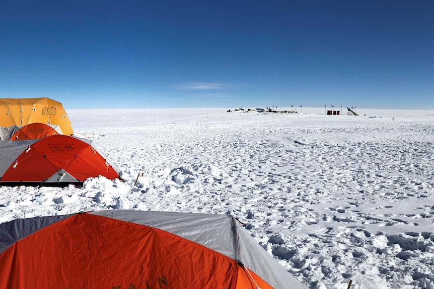 A camp in Antarctica with tents on a cloudless day