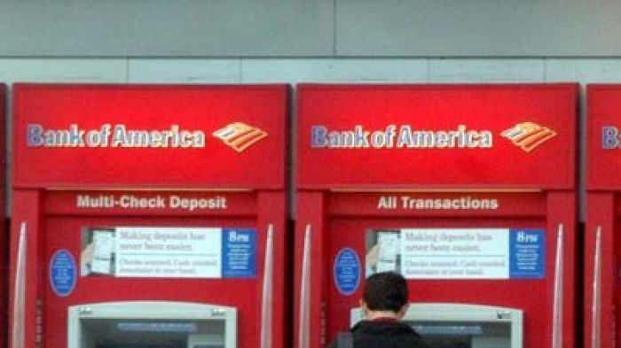 A man stands at a row of Bank of America ATM's