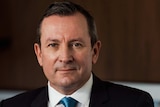 A headshot of Mark McGowan sitting in an office wearing a suit.