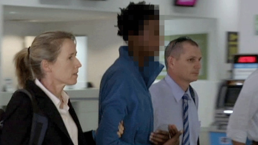 Queensland detectives escort Musa Ngwira through Cairns Airport today.