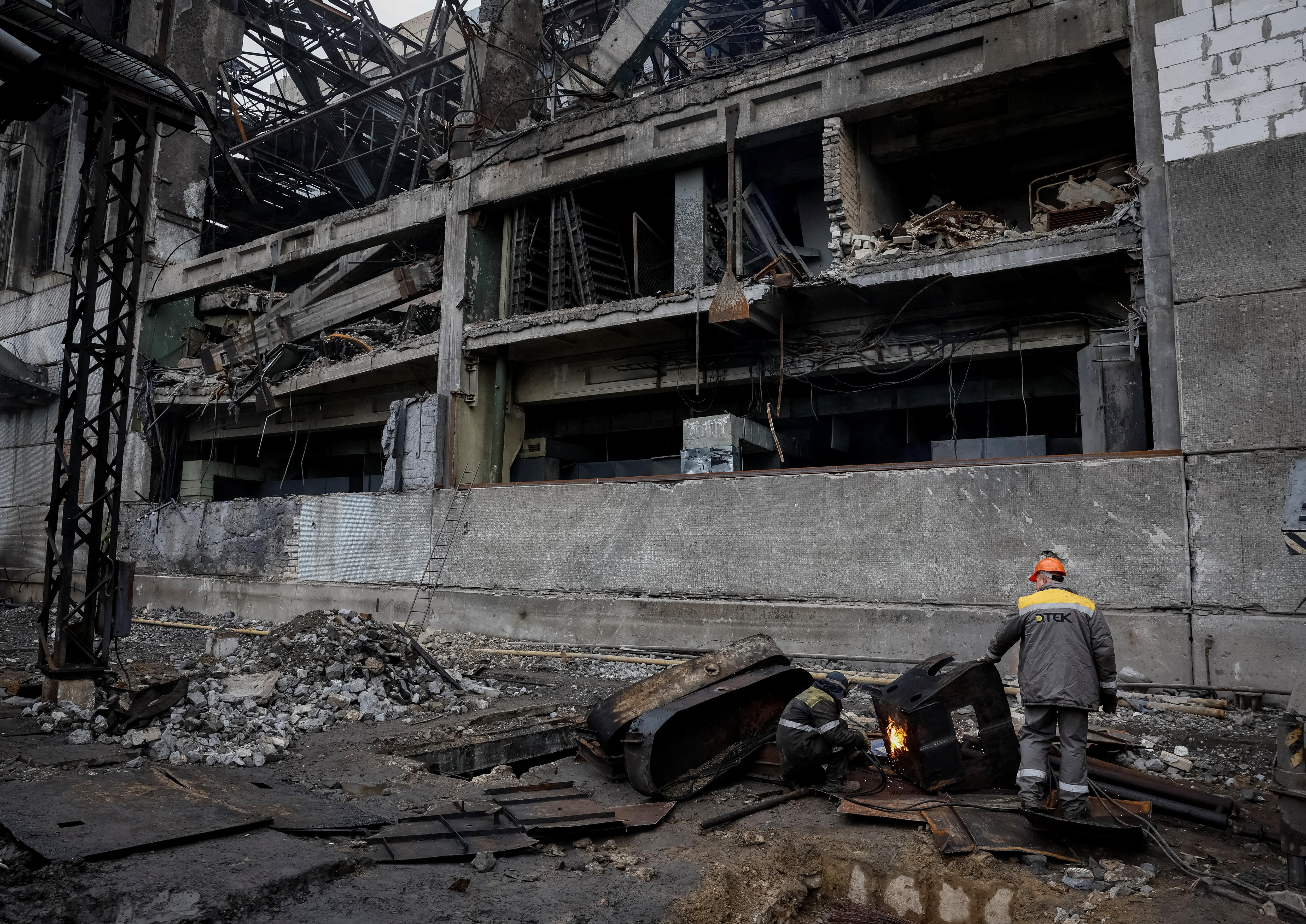 Employees work at a thermal power plant damaged by a recent Russian missile strike