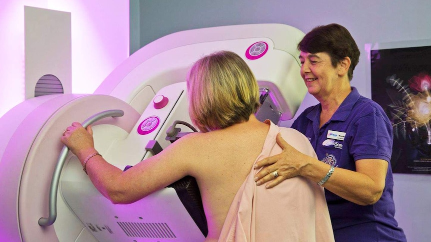 A woman facing away from camera is given a breast screen