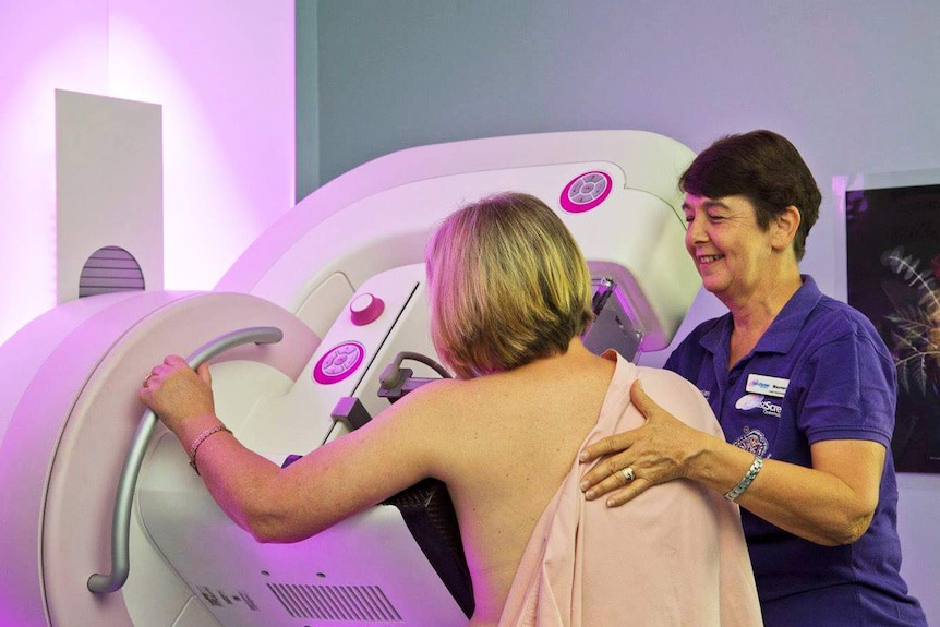 A woman facing away from camera is given a breast screen