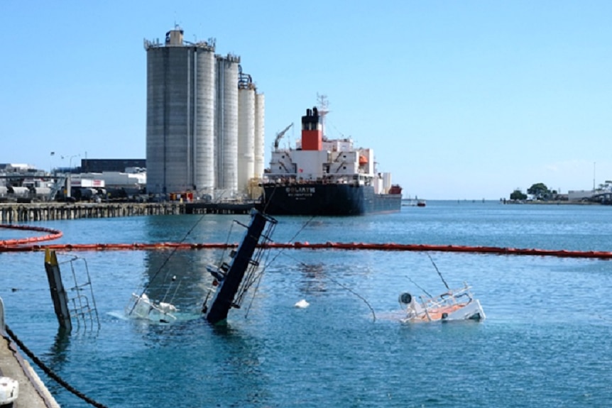 Partially submerged tugboats York Cove and Campbell Cove with the Goliath ship in background.