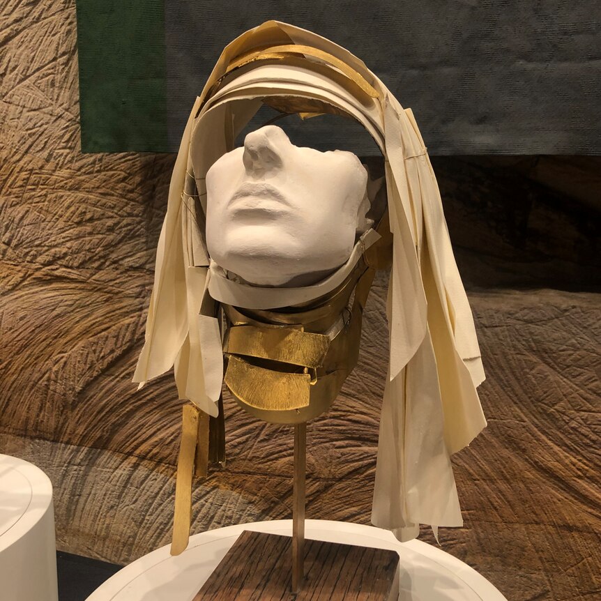 A bust of Hildegard von Bingen. Her habit is made with cotton rag paper and her collar is decorated with gold leaf.