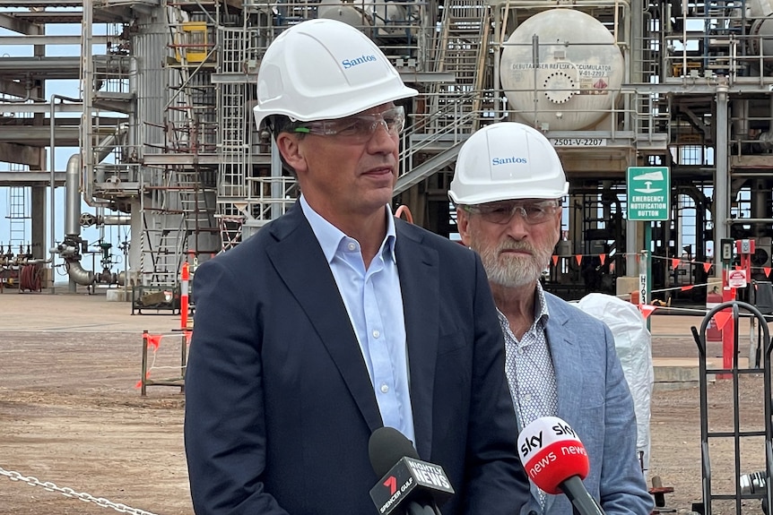 Two men wearing hard hats at a processing plant