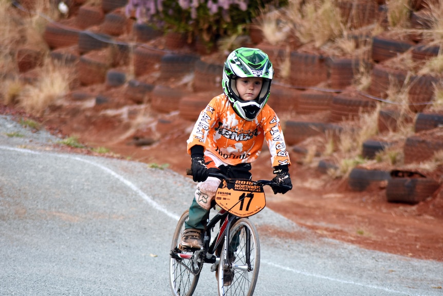 A young boy on a BMX bike in a helmet