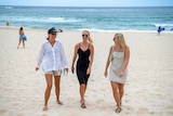 Three women walking on the beach 