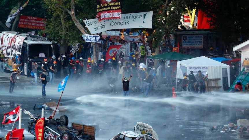 Turkish riot police fire a water cannon on Gezi Park protesters at Taksim Square in Istanbul.