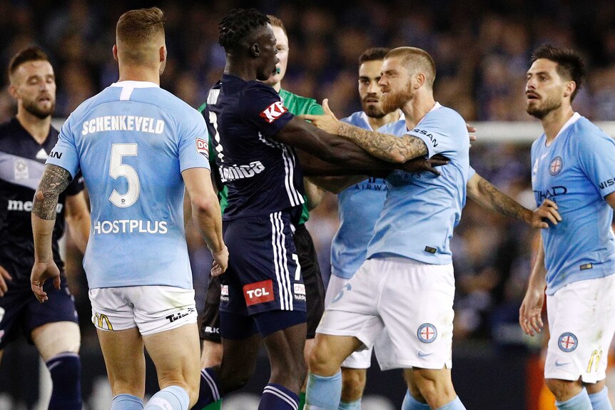 Kenny Athiu of the Victory and Luke Brattan of City tussle during the round one A-League match in Melbourne.