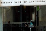 Reflection of people passing by the Reserve Bank of Australia in Sydney