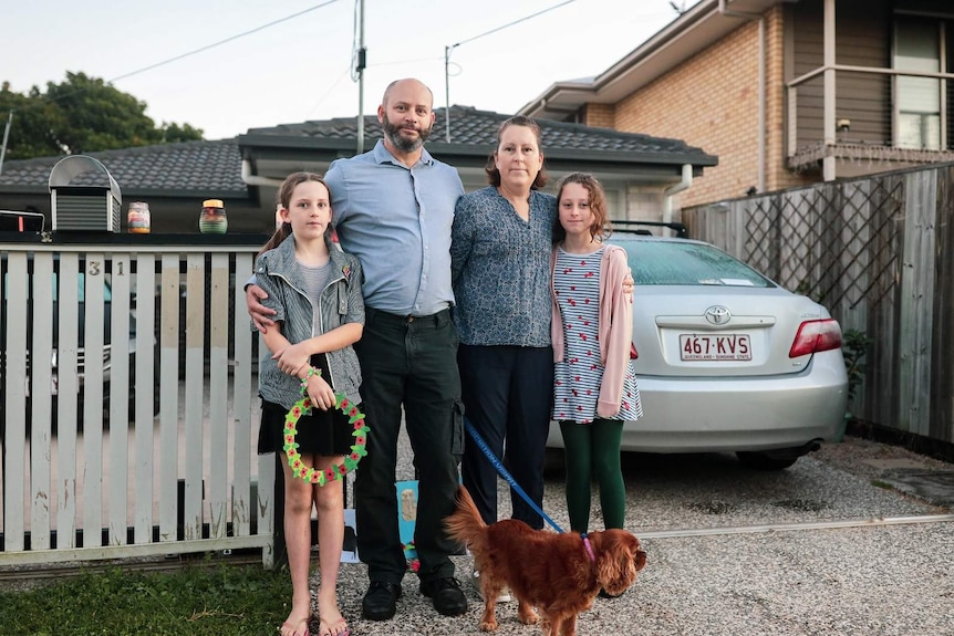 A family of four standing at the end of their driveway