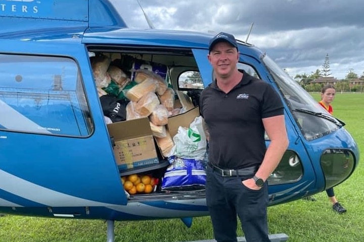 Sea World Helicopters pilot Ash Jenkinson with helicopter full of supplies behind for flood-affected communities in northern NSW
