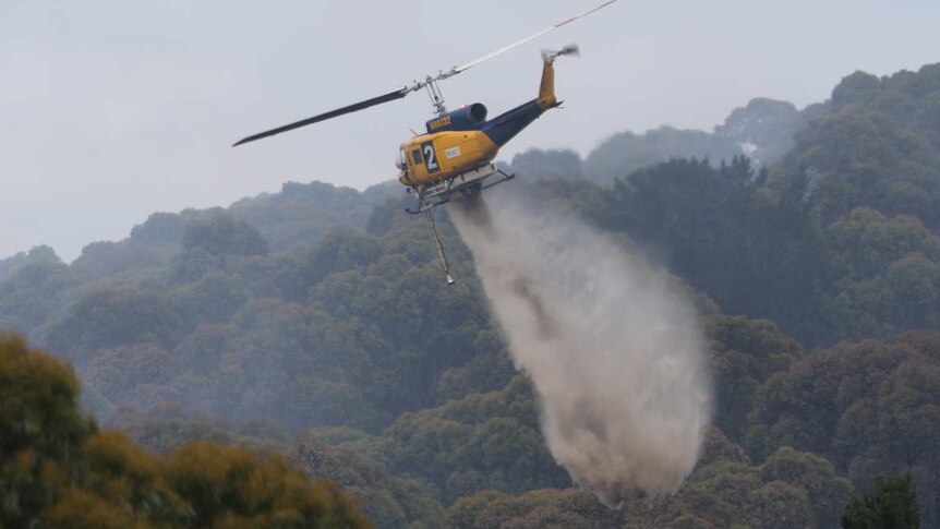 Helicopter waterbombs a fire at Bruny Island, Tasmania, Christmas Day, 2018.