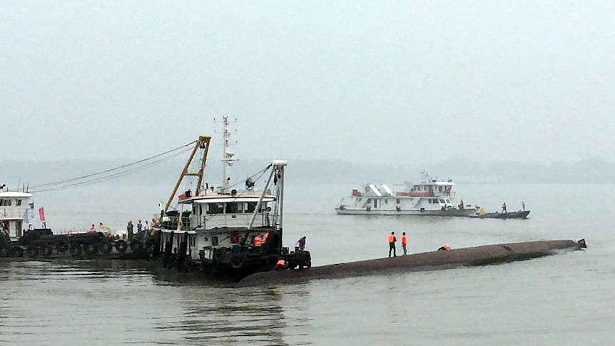 Rescue workers search on a passenger ship which sunk on the Yangtze river
