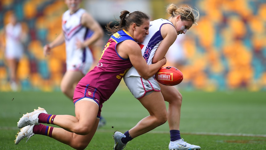 Brisbane Lions' Breanna Koenen drags down Fremantle Dockers' Nikki Gore during an AFLW match.