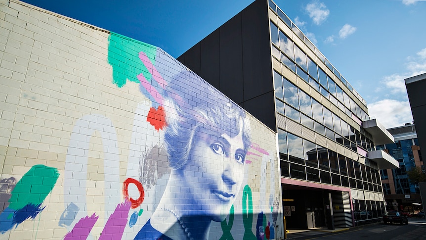A colourful mural of a woman on the wall of a building in Adelaide.