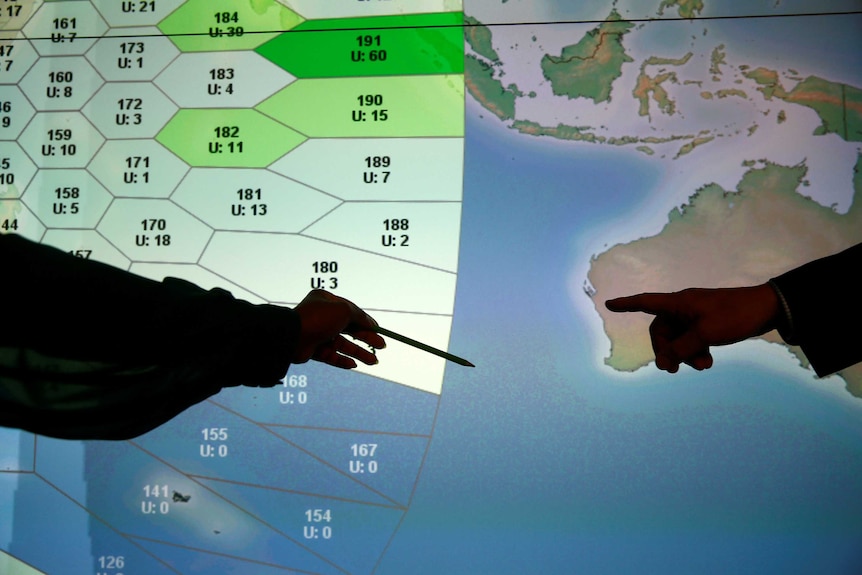 Member of staff at satellite communications company Inmarsat point to a MH370 search zone.