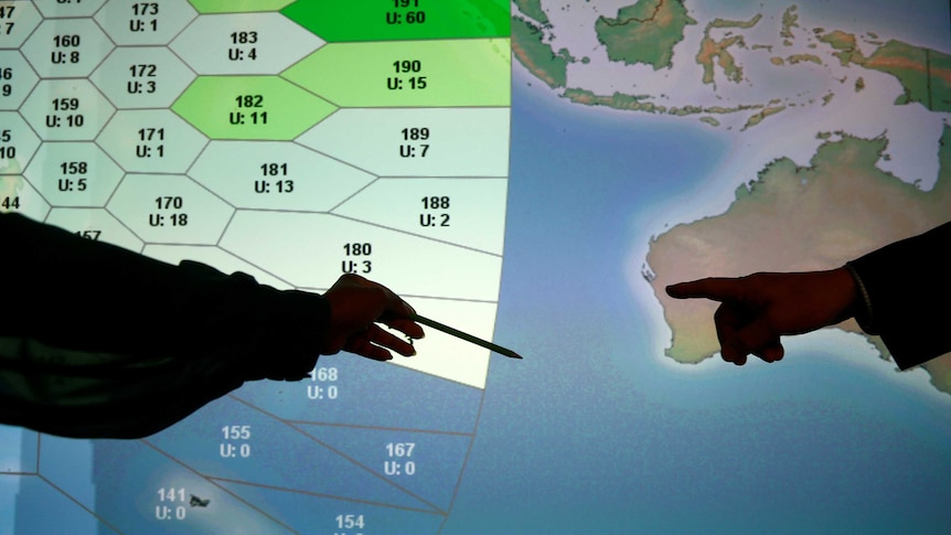 Member of staff at satellite communications company Inmarsat point to a MH370 search zone.