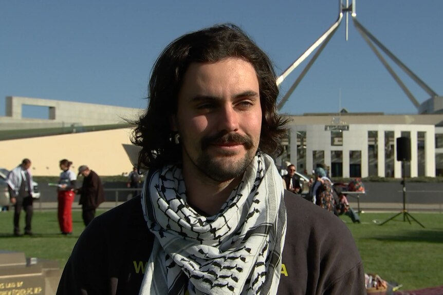 A man in front of Parliament House.