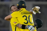 Australian cricketers Matthew Wade and Pat Cummins hug after beating India in a Twenty20 cricket match.