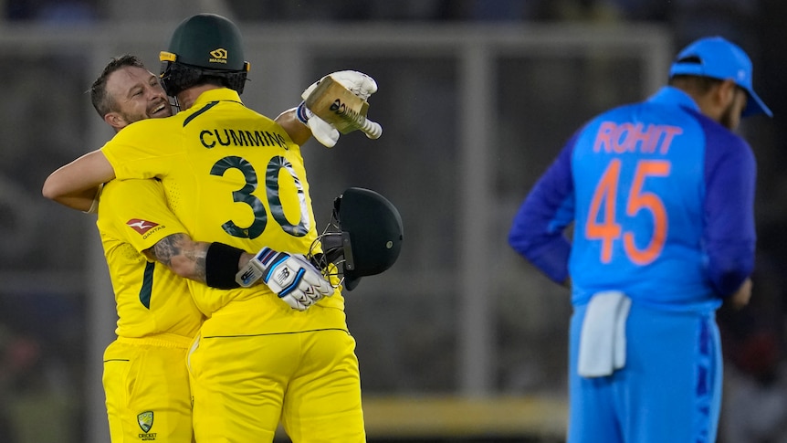 Australian cricketers Matthew Wade and Pat Cummins hug after beating India (AP: Manish Swarup)