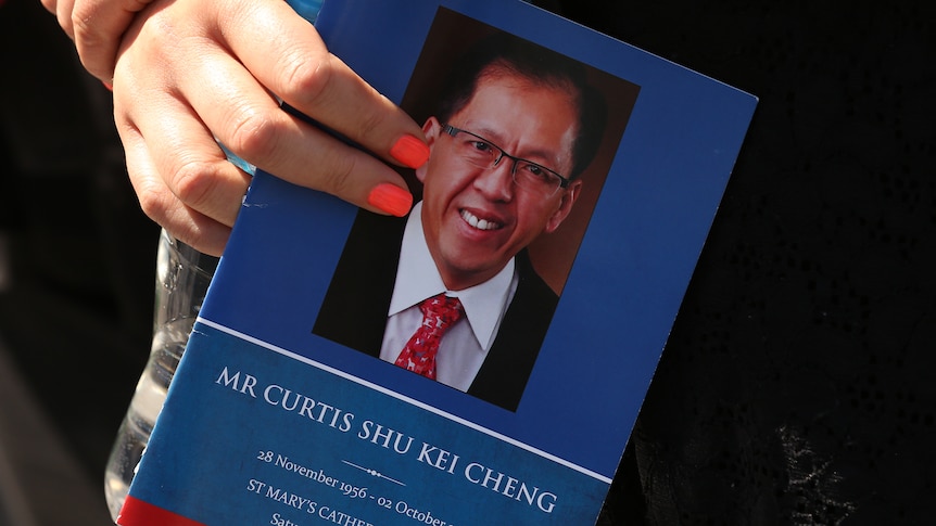 a woman holding a funeral flyer 