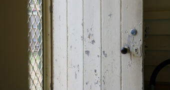 The paint cracks and peels away on a door leading to the backyard of the Whittaker's home