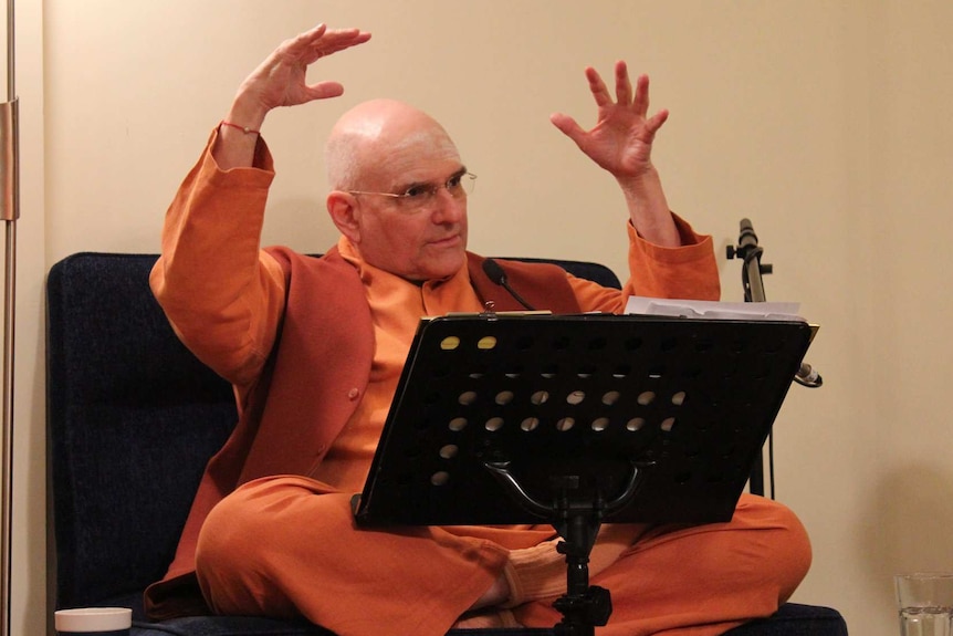 Russell Kruckman gestures with both his hands above his head while addressing his followers at Mt Eliza ashram.