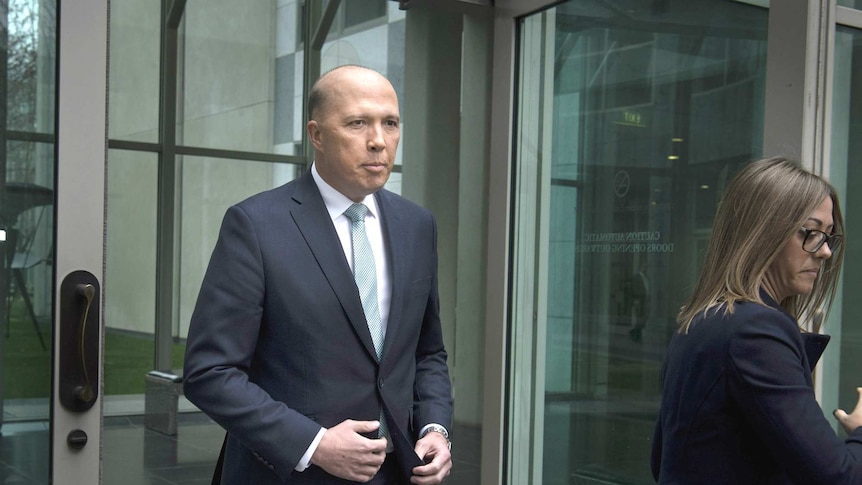 Peter Dutton walks out of Parliament, with a staffer nearby