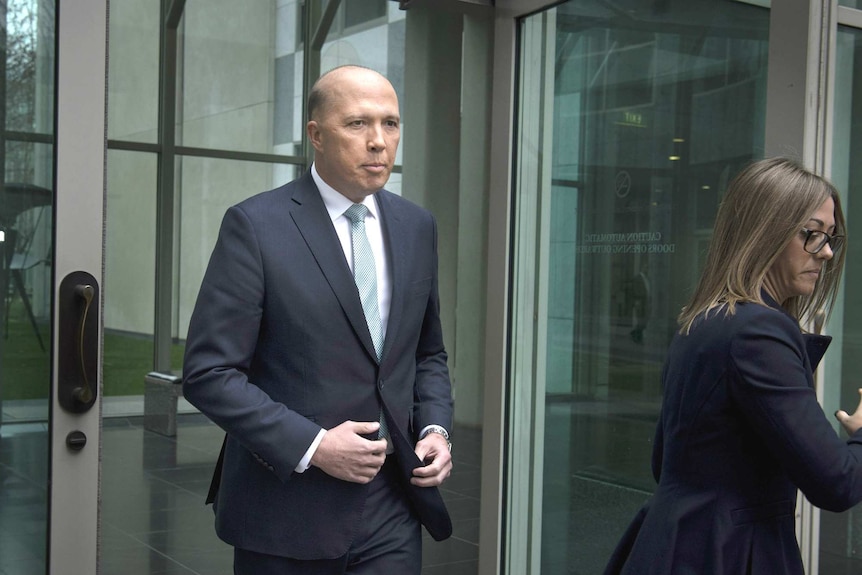 Peter Dutton walks out of Parliament, with a staffer nearby