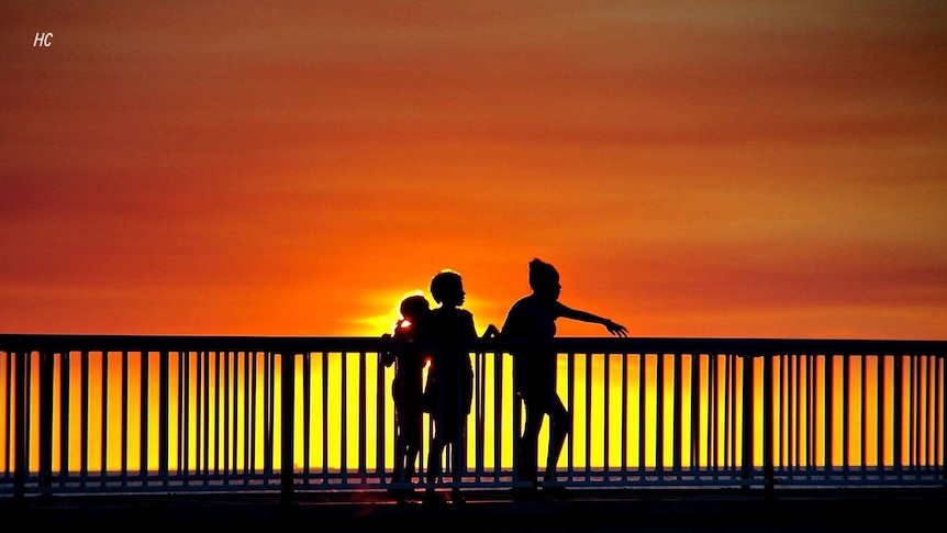 People walk across a jetty in Darwin