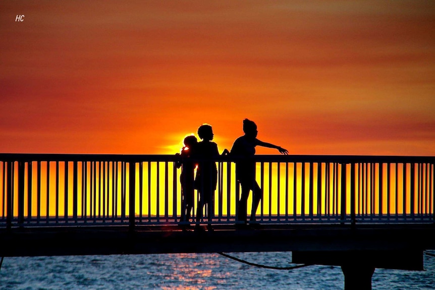 People walk across a jetty in Darwin