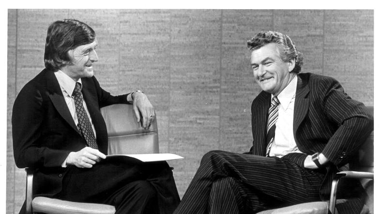 A black and white photo o presenter Michael Parkinson (left) interviewing Bob Hawke (right) on his TV show.