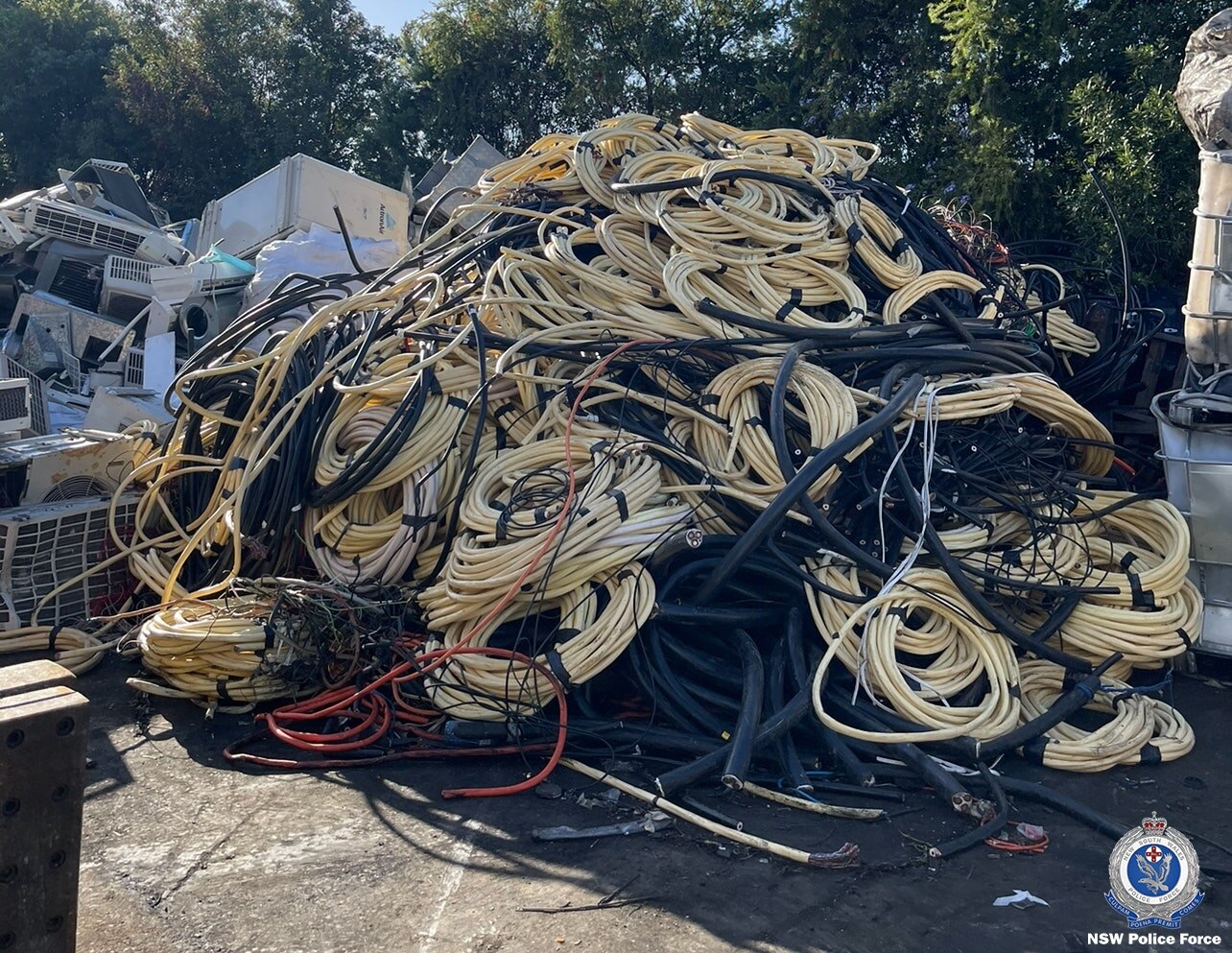 A large pile of cables are piled up next to each other in a car park.