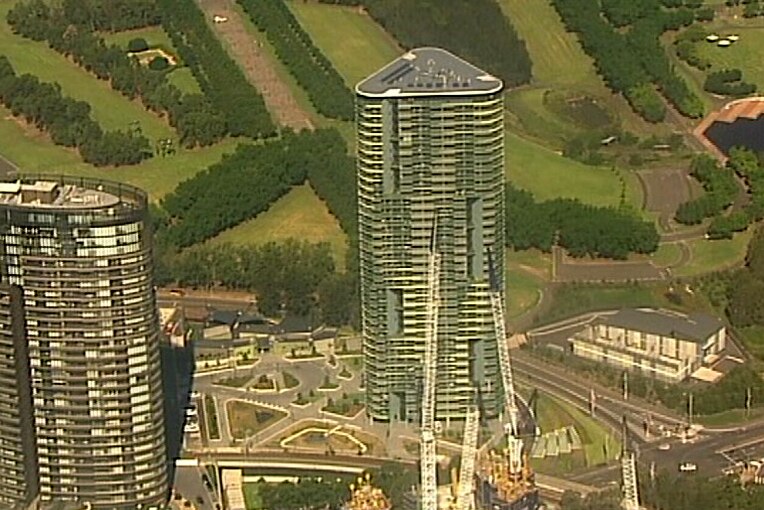 Two high-rise buildings jut above a construction zone, the triangular-shaped building in the centre.