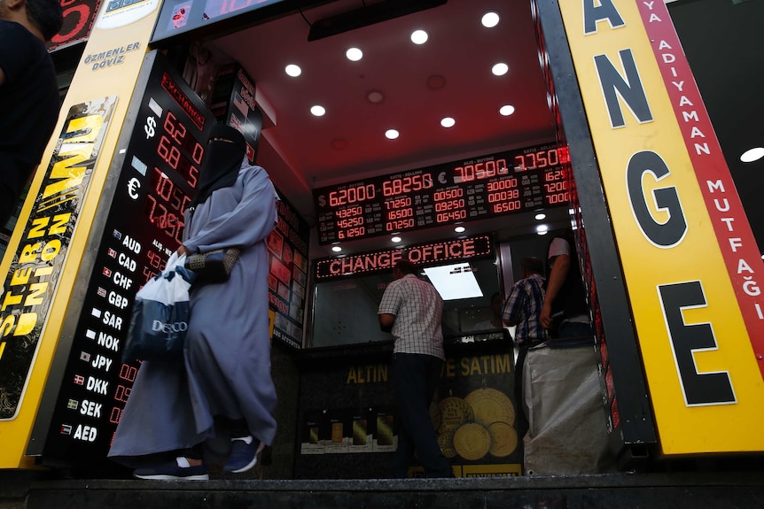 A woman leaves a currency exchange shop.